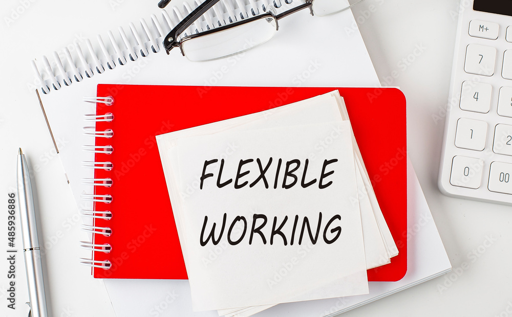 Aufkleber flexible working word on sticker on notepad with pen and calculator