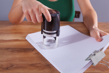 woman leaves stamp on paper