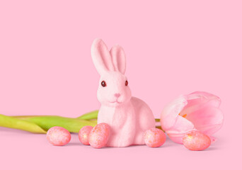 Cute Easter bunny with eggs and flower on pink background