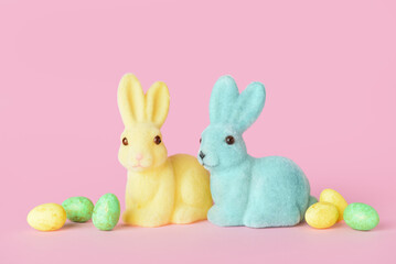 Cute Easter bunnies and eggs on pink background