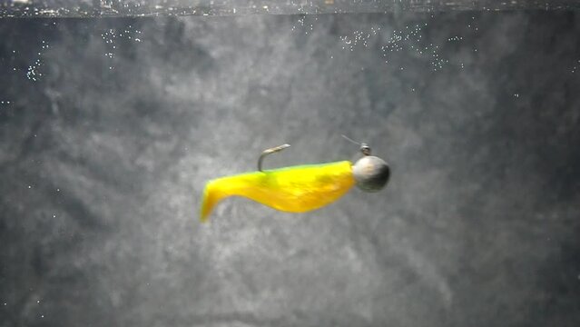 Artificial bait for fishing in the water. The vibrotail swims in the water. Silicone bait
