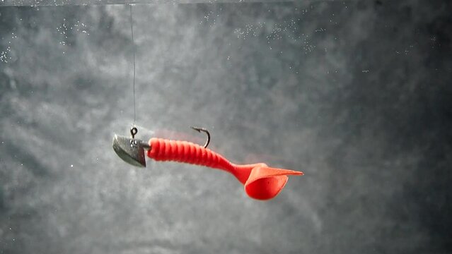 Artificial bait for fishing in the water. The vibrotail swims in the water. Silicone bait. Twister for spinning
