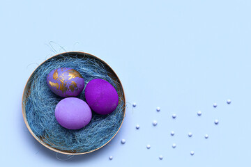 Plate with colorful Easter eggs on color background