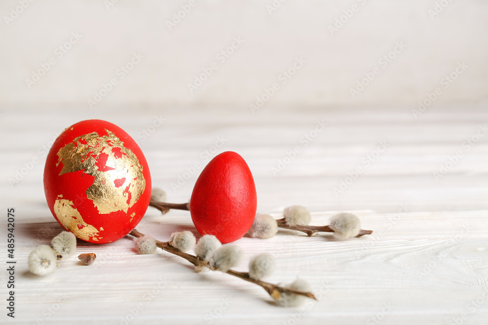 Sticker beautiful easter eggs and pussy willow branches on light wooden table