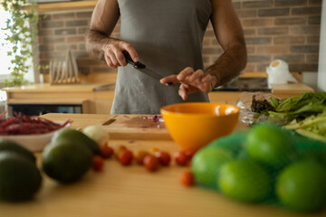 Happy and healthy young man meal prepping whole vegetarian meal in the kitchen. High quality photo