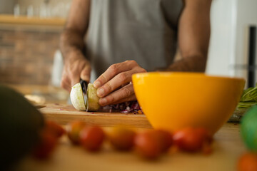 Happy and healthy young man meal prepping whole vegetarian meal in the kitchen. High quality photo