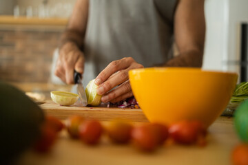 Happy and healthy young man meal prepping whole vegetarian meal in the kitchen. High quality photo