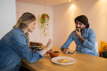Young couple in love eating a super healthy guacamole salad with whole toast in the kitchen. High quality photo