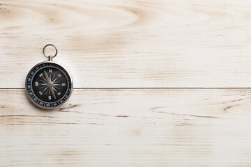 Old compass on wooden background