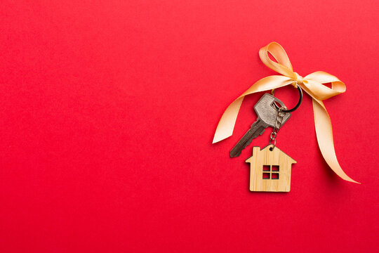 House key with golden bow on color background