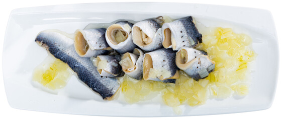 Delicious herring fillet with onion and sunflower oil, laid out on a plate. Isolated over white...