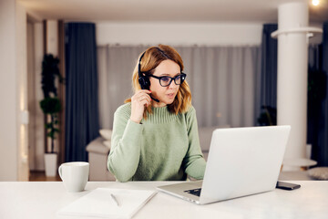 A businesswoman having video call on the laptop from her cozy home.