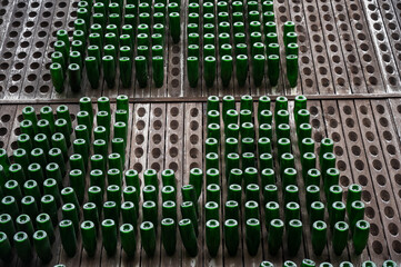 Bottles of wine are stored in wooden shelves with holes.