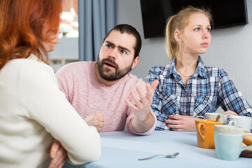 Young serious couple has a family stressful conversation at home. High quality photo