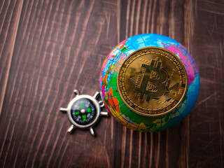 Top view compass,earth globe and bitcoin on a wooden background.