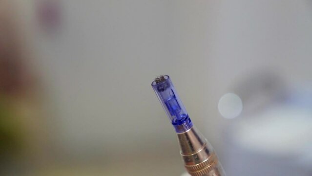 Close-up shot of a microneedling pen moving in slow motion.