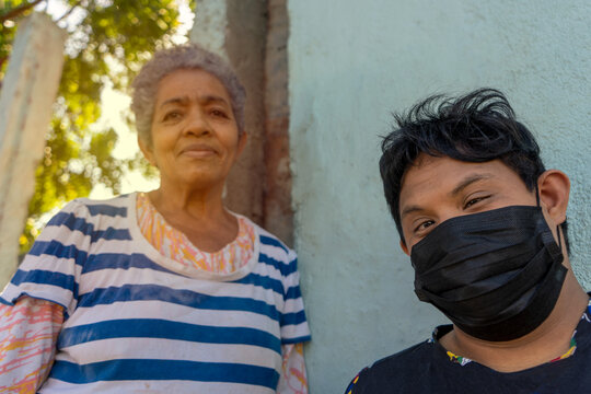 Latin Adult Woman With Her Son With Down Syndrome Wearing A Mask For The Coronavirus