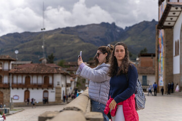 Friends taking pictures with the mobile of a traditional andean town