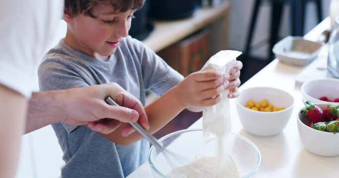 Lots of fun and a whole lotta yum. 4k video footage of an adorable little boy baking with his father at home.