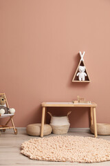 Cute child room interior with furniture, toys and wigwam shaped shelf on pink wall © New Africa