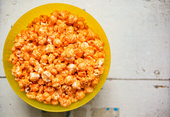 A plate of sweet popcorn on an old white table