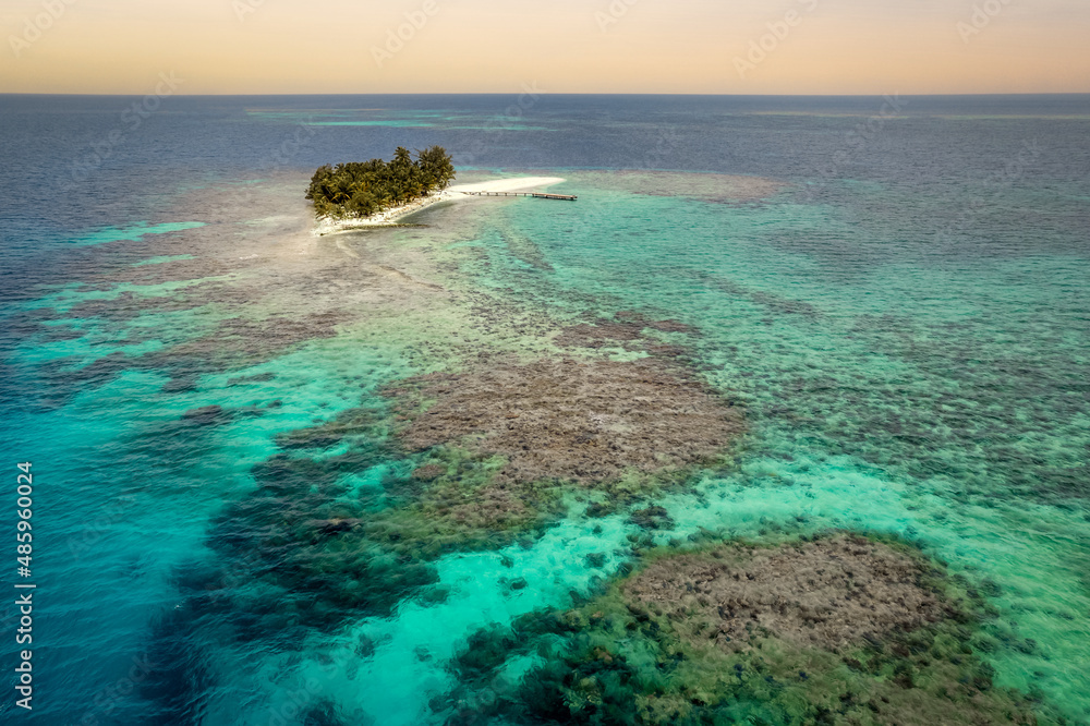 Wall mural remote island surrounded by turquoise waters and beautiful underwater reef