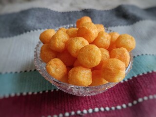 Cheese puffs balls, cheese curls, cheese ball puffs, cheesy puffs, or corn curls are a puffed corn snack, coated with a mixture of cheese or cheese-flavored powders.