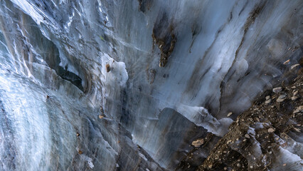 Layers of an ancient glacier wall with frozen stones 