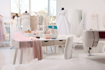 Dressmaking workshop interior with wedding dresses and equipment