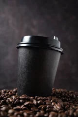 Photo sur Plexiglas Café black paper cup with coffee beans on a dark background close up and macro. The concept of eco and zero waste. Eco-friendly use. Mock up and copy space