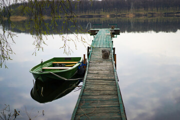 Boat near a wooden long bridge, on the lake