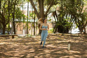 Young woman running and jogging at a park outdoors. Athlete female person during workout. High quality photo