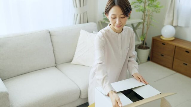 60p　ダンボールに衣服を入れるミドル女性