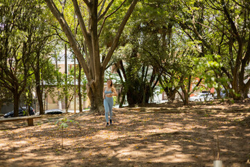 Fototapeta premium Young woman running and jogging at a park outdoors. Athlete female person during workout. High quality photo