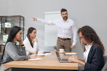 Man screaming at African American woman in office. Racism concept