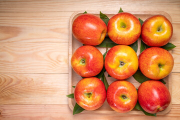 Naklejka na ściany i meble Fresh red Envy apple on wooden background. Envy apple on wooden box packaging ready to sell.