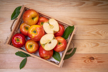 Fresh red Envy apple in wooden basket on wooden background. Envy apple on wooden box packaging...