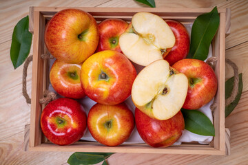 Fresh red Envy apple in wooden basket on wooden background. Envy apple on wooden box packaging ready to sell.