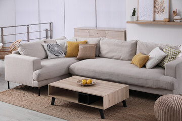 Stylish living room interior with comfortable grey sofa and coffee table