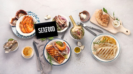 Grilled fish and seafood assortment on light background.