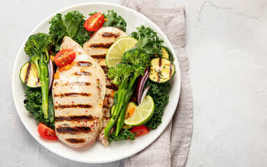 Grilled chicken with vegetables on light background.
