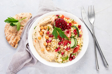 Bulgur and hummus salad on light background.