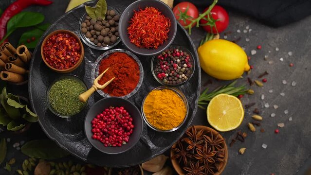 Collection of spices. Dried various herbs and spices for cooking in bowls on a black table. View from above