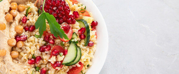 Bulgur and hummus salad on light background.