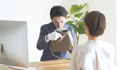 バッグの査定,鑑定をするアジア人男性