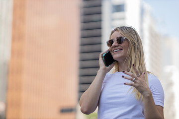 Young woman using a smartphone at day time with city view landscape in the background. High quality photo