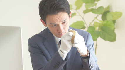 時計の鑑定・査定をするアジア人 © ponta1414