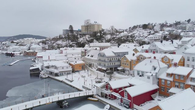 Road Bridge By The Kragerø Harbor In Norway With Snow-covered Waterfront Buildings At Winter. aerial drone