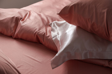Fototapeta na wymiar Closeup view of bed with beautiful silk linens