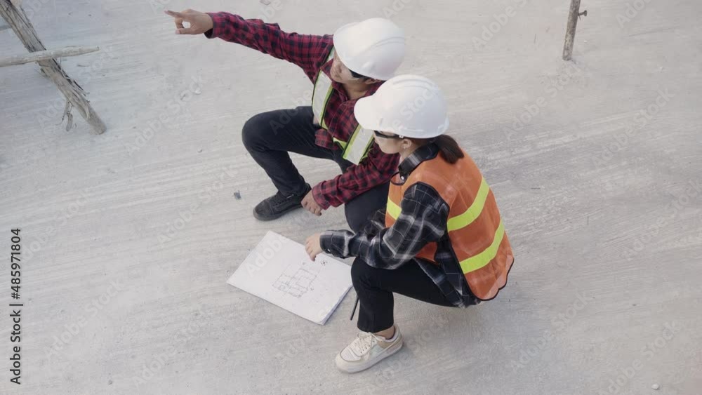 Poster architect and client discuss help create plan with blueprint of the building at construction site fl